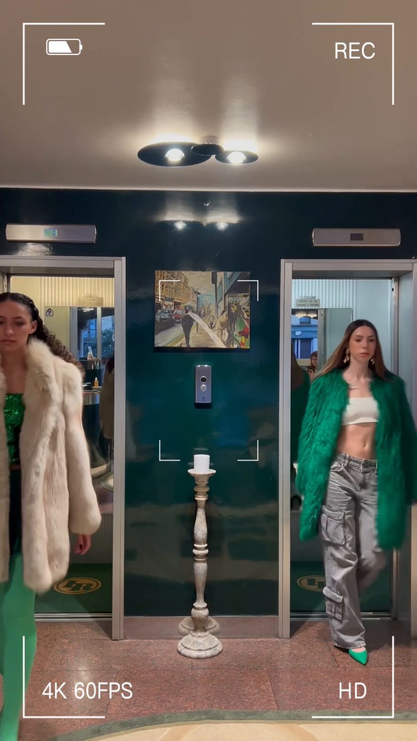 Still from the campaign film — both characters framed either side of a metro doorway, with a camcorder overlay across the frame